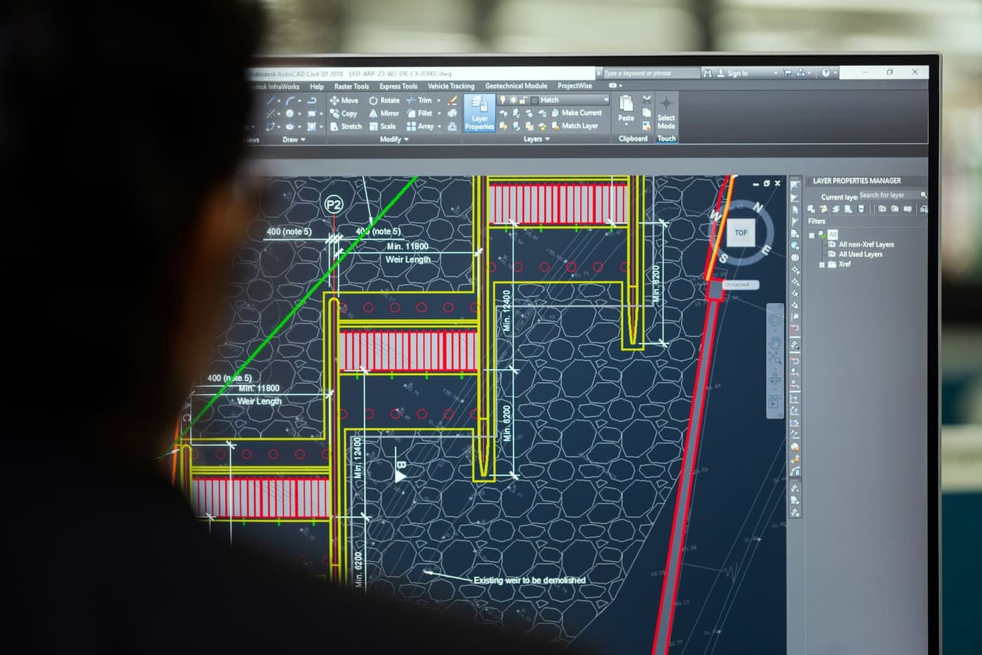 Engineer reviewing detailed civil and site plans in CAD software
