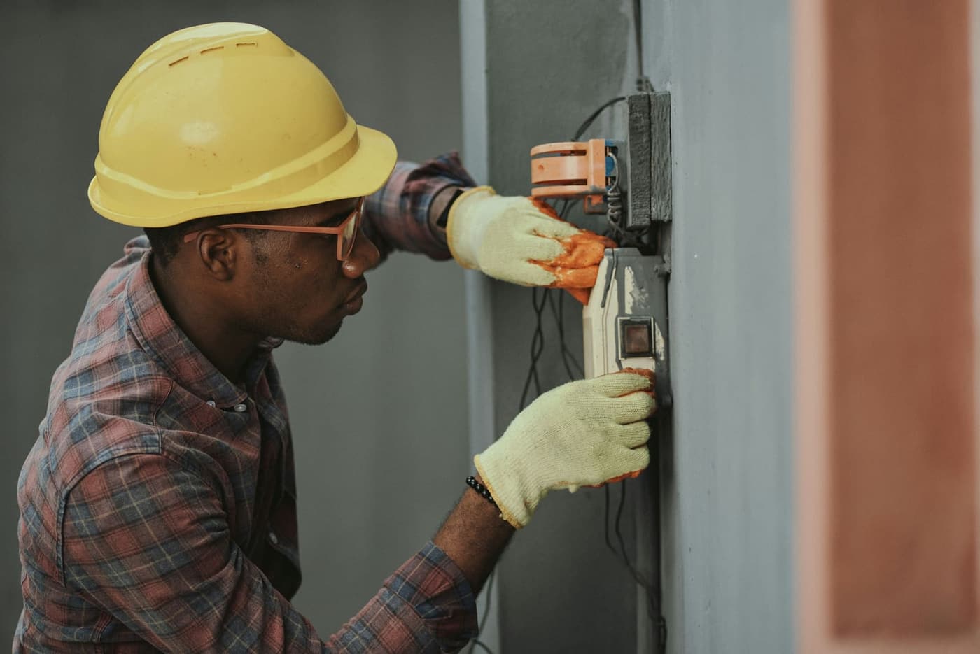 Trades professional in hard hat commissioning electrical systems on a commercial project