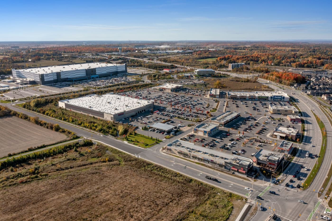 Aerial view of a vacant land parcel beside commercial and industrial development